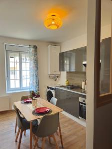 une cuisine et une salle à manger avec une table et des chaises dans l'établissement Charmant appartement, spacieux et tout confort, à Charleville-Mézières