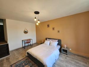 une chambre avec un lit et une table dedans dans l'établissement Charmant appartement, spacieux et tout confort, à Charleville-Mézières