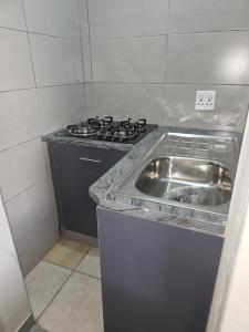 una cocina con fregadero y estufa en The Good Samaritan 2, en Witbank 4 fotos más