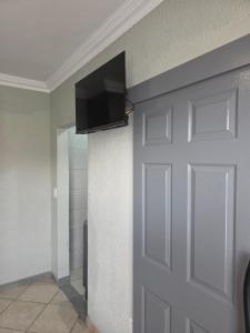 Un televisor de pantalla plana en una pared junto a una puerta. en The Good Samaritan 2, en Witbank