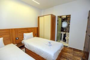 a bedroom with two beds and a bathroom at The Sacred Angle pyramids View in Cairo +80 photos