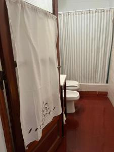a bathroom with a toilet and a shower curtain at Villa Paula in Ranchos