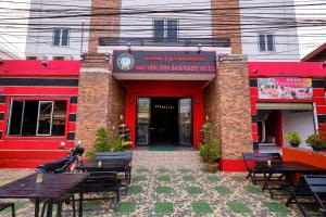 a restaurant with tables and benches in front of it at The Drift House Hostel in Vang Vieng