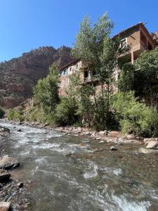 un río con un edificio a un lado de una montaña en Gite Ifoulou Tassaout, en Ifoulo