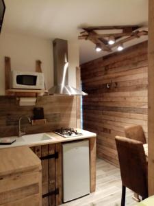 a kitchen with a stove and a sink and a microwave at Le paon de bois avec bain nordique in Saint-Mards-en-Othe
