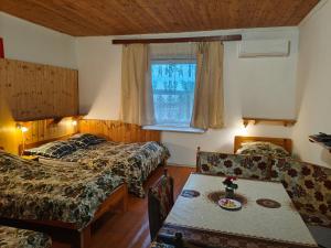 a bedroom with two beds and a table and a table sidx sidx sidx at Akácvirág Vendégház in Ács