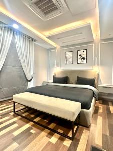 拉合尔Gold crest mall Two Bed Luxury Apartment - Mirhaa Homes的一间卧室配有一张大床,内有长凳