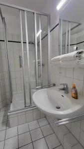 a white bathroom with a shower and a sink at Ankerplatz Lichtblick in Travemünde +19 photos