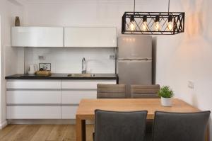 a kitchen with a table with chairs and a refrigerator at sea of Galilee 612 in Tiberias +3 photos