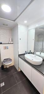 a bathroom with a large white sink and a toilet at sea of Galilee 612 in Tiberias