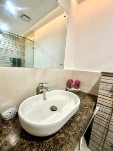 拉合尔Gold crest mall Two Bed Luxury Apartment - Mirhaa Homes的浴室里有一面镜子的白色水槽 更多33张照片