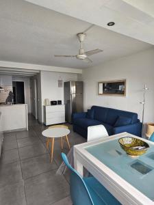 a living room with a blue couch and a table at Portvendres Sea view in Port-Vendres