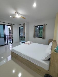 a white bedroom with a large bed and windows at Krabi Rooms - Appartment 4 in Krabi town +1 photo