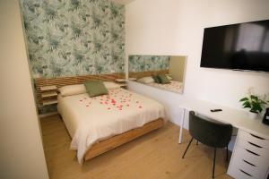 a bedroom with a bed and a desk with a monitor at Attimo d'amore in Quinto Vicentino
