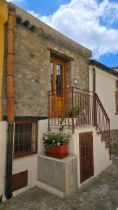 a stone building with a balcony and a porch at A Casuzza in Caronia