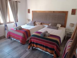 Dos camas una al lado de la otra en un dormitorio. en Cabañas La Nochera, en Tilcara