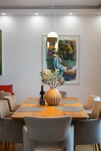 ein Esstisch mit Stühlen und ein Gemälde an der Wand in der Unterkunft Vienna Deluxe Residences - Schönbrunn in Wien + 25 Fotos