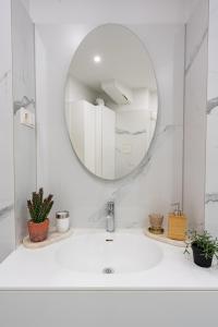 ein weißes Badezimmer mit Waschbecken und Spiegel in der Unterkunft Vienna Deluxe Residences - Schönbrunn in Wien