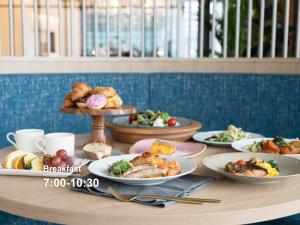 a table with plates of food on a table at Mitsui Garden Hotel Yokohama Minatomirai Premier in Yokohama