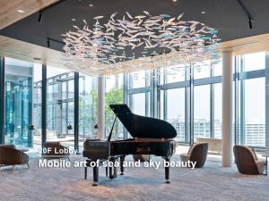 a piano in a room with a chandelier at Mitsui Garden Hotel Yokohama Minatomirai Premier in Yokohama
