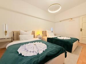 een slaapkamer met twee bedden met groene lakens en een parasol erop bij DREAMZzz Marktblick - Altstadt Suite in Coburg in Coburg