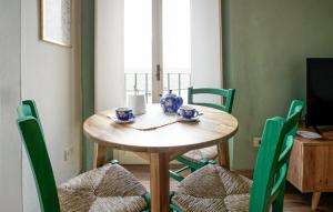 a dining room table with green chairs and a table with cups at Galletto del Chianti in Panzano
