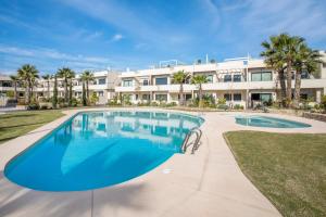 a large swimming pool in front of a building at Private jacuzzi, heated pool, summer kitchen, AC in Torrevieja