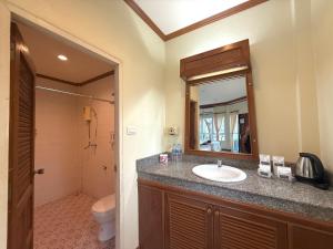 ein Badezimmer mit Waschbecken, Toilette und Spiegel in der Unterkunft Lanta Palm Beach Resort , Beach Bungalow - Koh Lanta in Ko Lanta