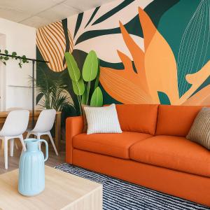 an orange couch in a living room with a mural at The 708 - For 4 - Free Parking - BBQ in Quebec City