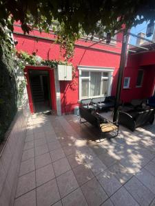 Un edificio rojo con dos bancos delante. en Şişli Suites - Room44, en Estambul