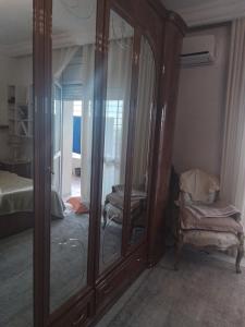 突尼斯Jasmin appart的带镜子和梳妆台的房间以及一间卧室