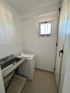 een kleine badkamer met een wastafel en een raam bij Dpto Bambú in Salta