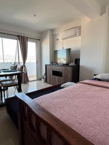 een slaapkamer met een bed en een flatscreen-tv bij Dpto Bambú in Salta