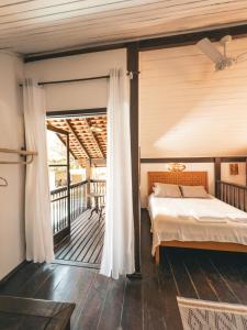 a bedroom with a bed and a balcony at Casa Pindorama - Chalé Opy in Paraty