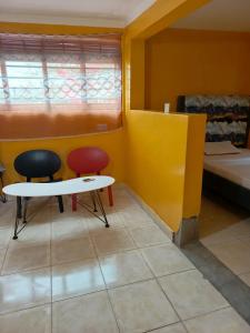 a room with two beds and a table and two chairs at Kio Farm2 in Kiserian