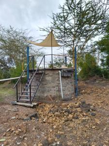 a building with a staircase and an umbrella at Kio Farm2 in Kiserian
