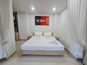 a bedroom with a bed in a white room at 41 квадратный метр, апартамент на пляже Сурин in Surin Beach +13 photos