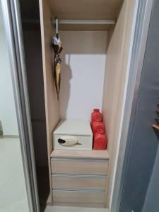 a closet with a toaster and two red pillows at 41 квадратный метр, апартамент на пляже Сурин in Surin Beach