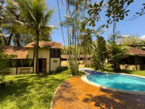 a villa with a swimming pool and a house at Casa Pindorama - Chalé Opy in Paraty