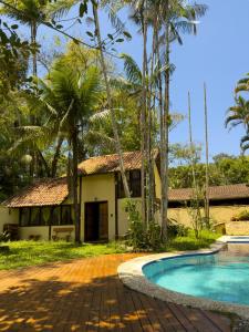 a villa with a swimming pool in front of a house at Casa Pindorama - Chalé Opy in Paraty