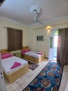 a bedroom with two beds and a ceiling at Gamal Robob Nubian Guest House in Aswan