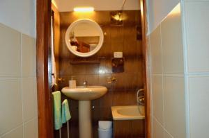 a small bathroom with a sink and a mirror at Le Scalette in Acquapendente +3 photos