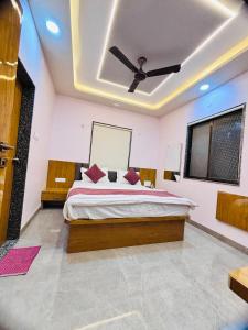 a bedroom with a bed with a ceiling fan at Sairam Residency in Ellora