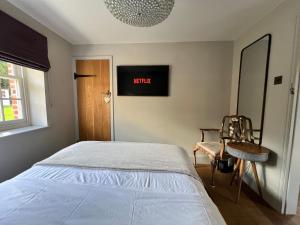 ShenfieldにあるGlanthams Lodge Guestroomのベッドと椅子と窓のある寝室 +2枚の写真