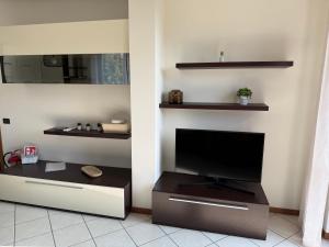 Una sala de estar con un televisor de pantalla plana en una pared. en 5 min to Equieffe & Private Parking - Teo House, en Gorla Maggiore