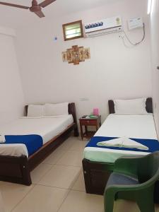 a room with two beds and a chair in it at De Dreams beach in Puducherry +9 photos