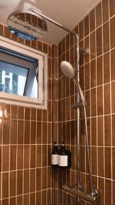 ein Duschkopf in einem Badezimmer mit braun gefliesten Wänden in der Unterkunft Busaba Ayutthaya Hotel in Phra Nakhon Si Ayutthaya