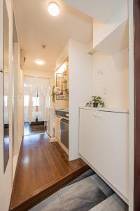 東京にあるsakura 202の白いキャビネットと木製の床を備えたキッチン