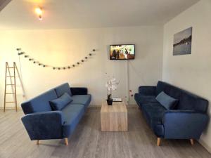 een woonkamer met twee blauwe banken en een salontafel bij Le Tribord T3 étoilé in Saint-Méloir-des-Ondes