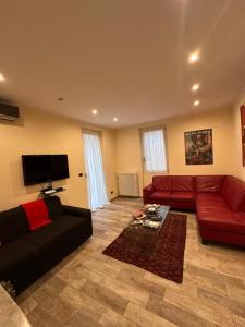 a living room with a red couch and a tv at SalitaCentrale6 in Bellagio